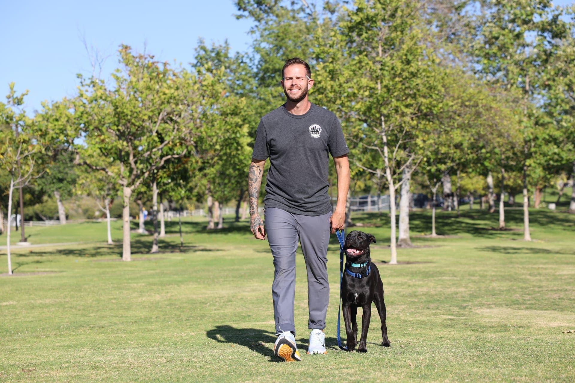 Jake walking with a happy black dog at Foothill Ranch Community Park in Orange County